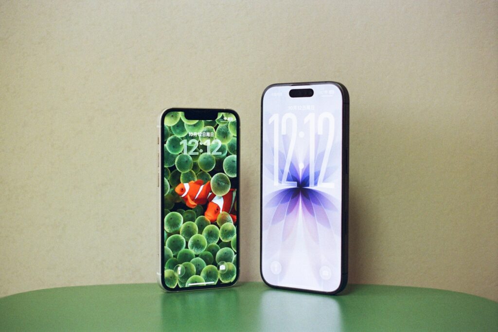Two smartphones displaying different wallpapers on a table