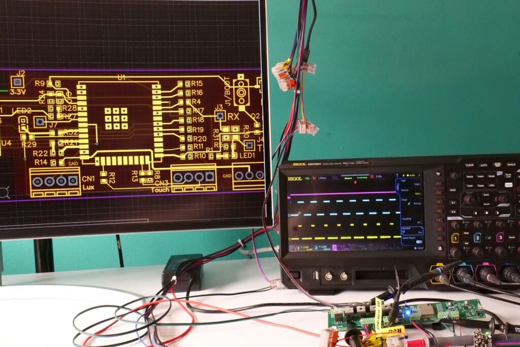 Engineers Workbench with oscilloscope and pcb and measurements and elctronic design layout sreen.