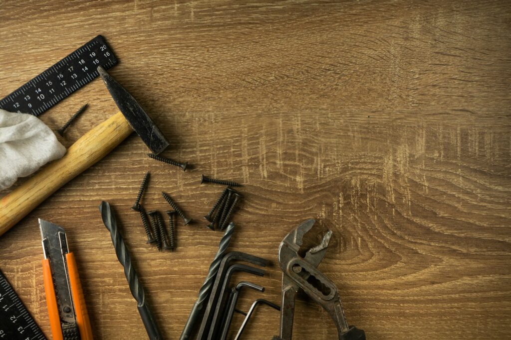 Home craftsman's tools lie on a wooden board